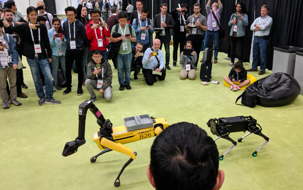 Boston Dynamics quadruped robot with arm and another quadruped.